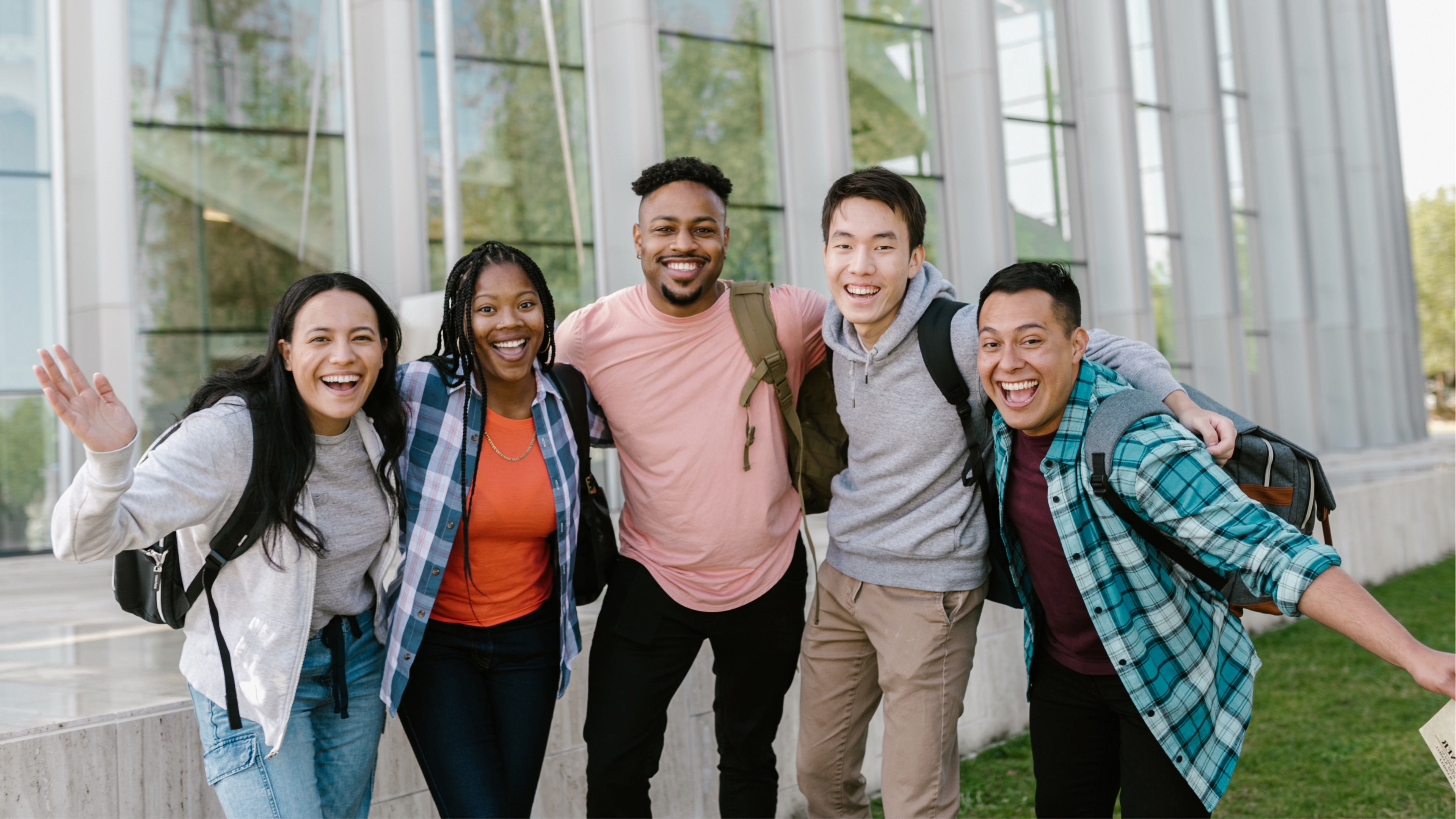 A diverse group of smiling TIA youth leaders standing together outdoors.