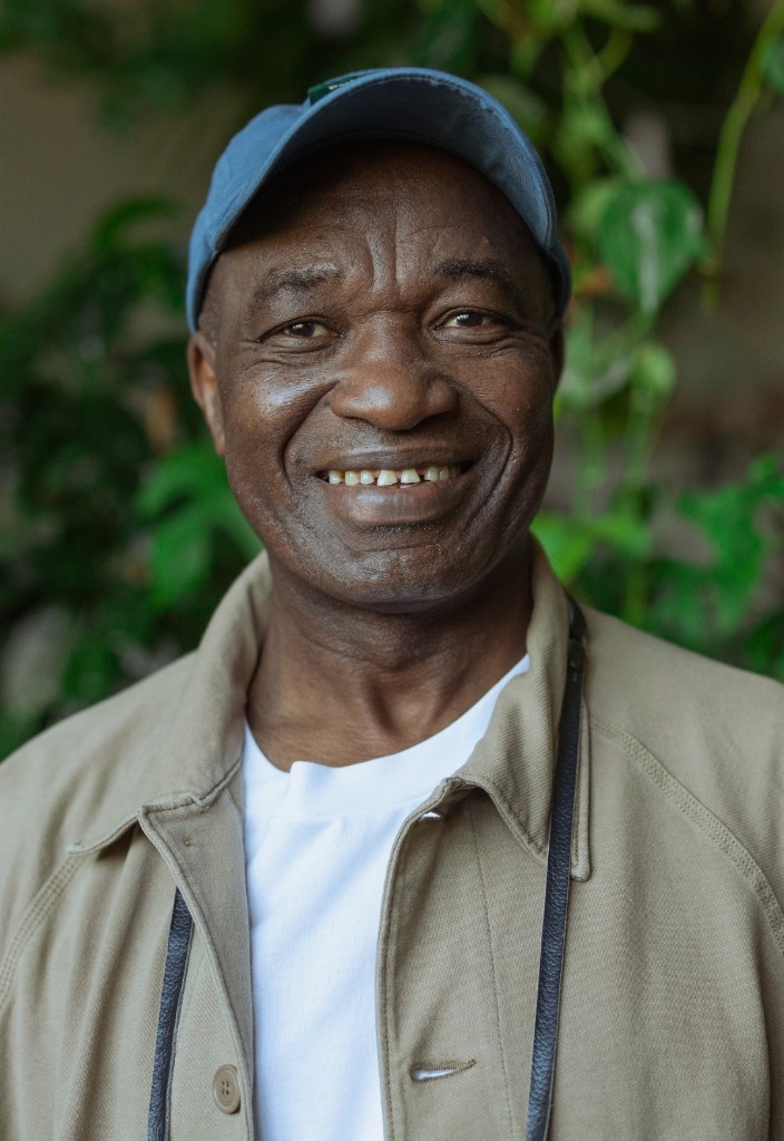 A smiling man wearing a blue cap outdoors