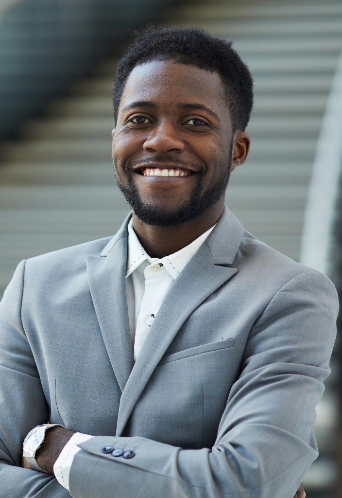 A smiling man in a light suit jacket